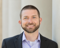 Man with beard smiling in a suit
