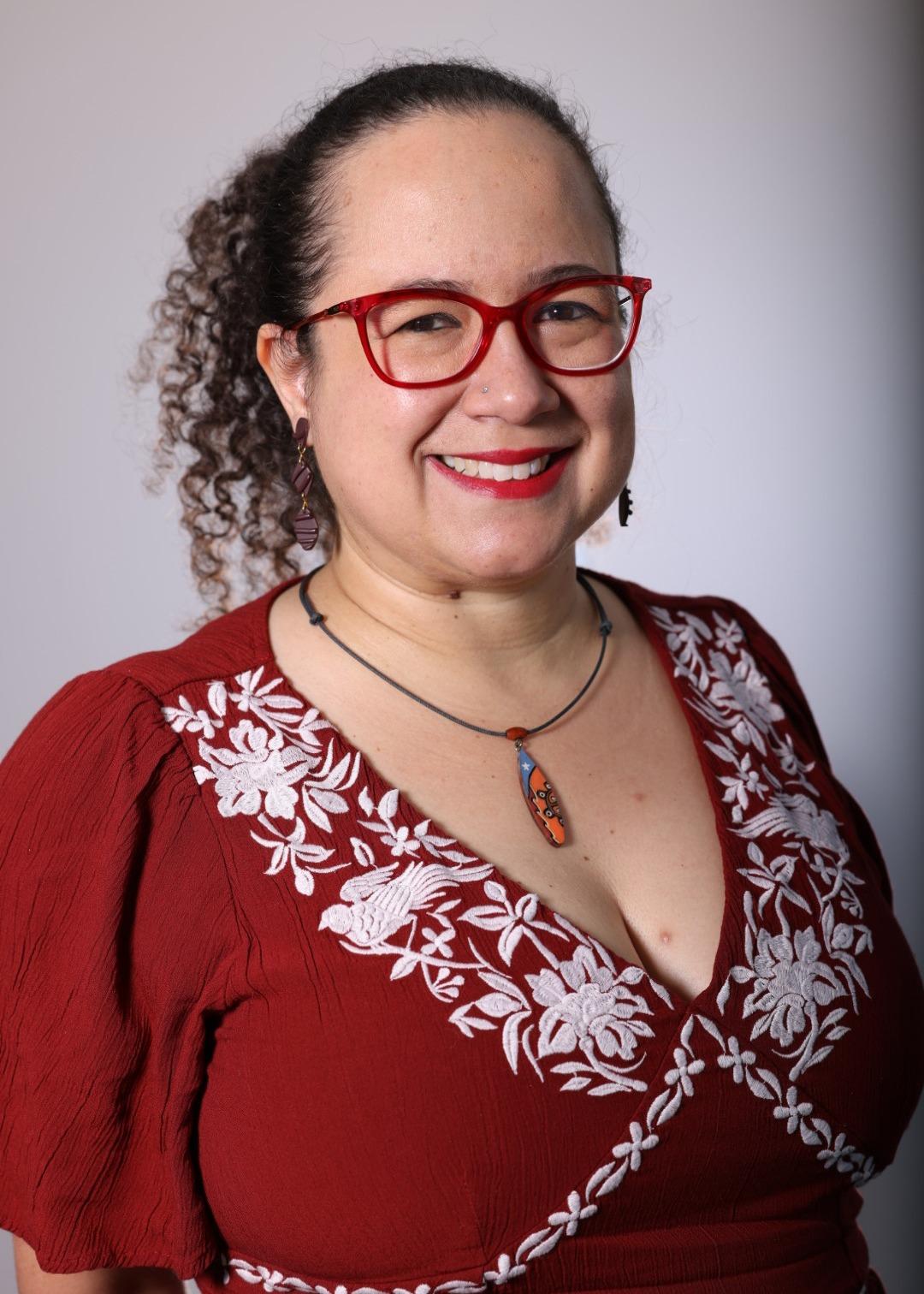 Older Hispanic woman poses for a professional headshot.